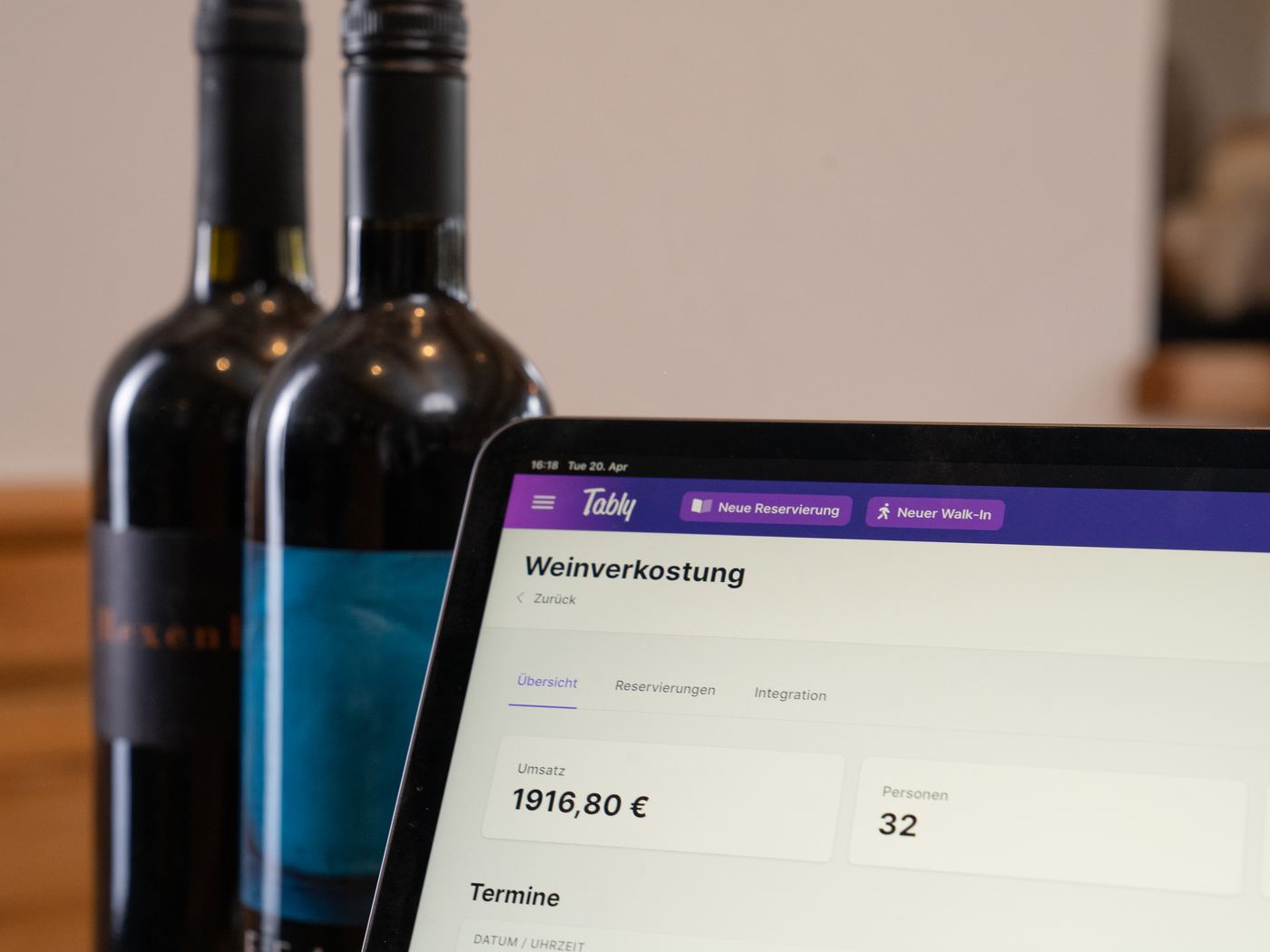 Weinflaschen und Tably-Event-Übersicht auf dem Tablet
